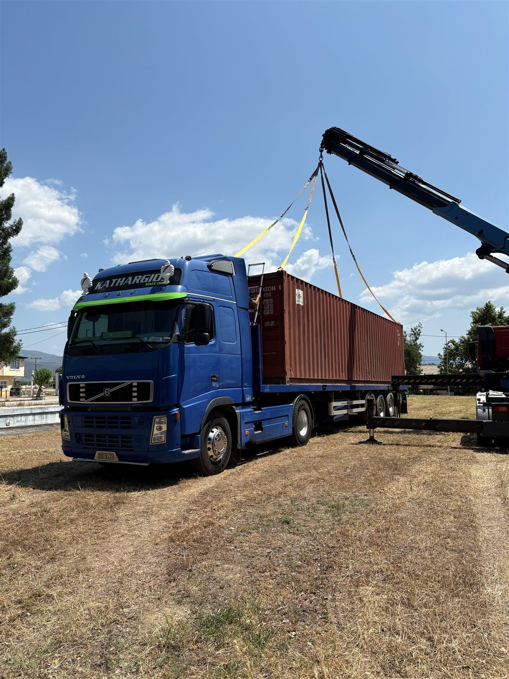 Μπλε φορτηγό Volvo Kathargios Group φορτώνεται με container